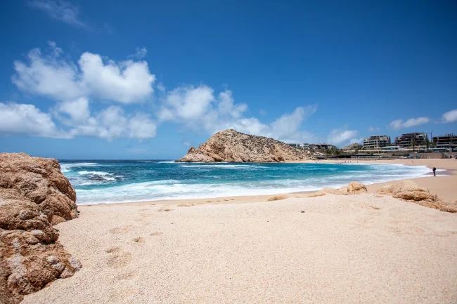 Santa Maria Bay beach in Los Cabos with turquoise water, golden sand, and rock formations under blue sky